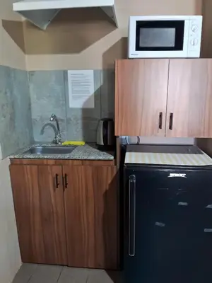 a kitchen with a sink and a microwave and a refrigerator at QUIRUS DORMIS in Villa Carlos Paz