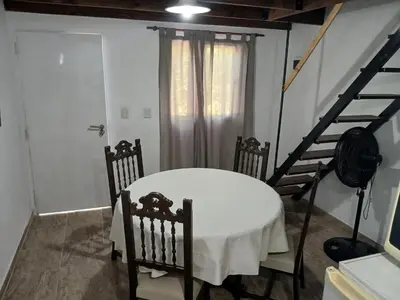 a dining room with a white table and chairs at Los jilgeros in Santa Rosa de Calamuchita