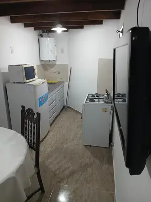 a small kitchen with a stove and a refrigerator at Los jilgeros in Santa Rosa de Calamuchita