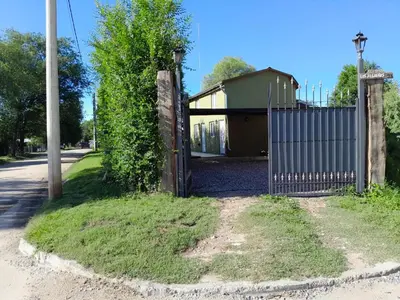 a gate in front of a building next to a street at Los jilgeros in Santa Rosa de Calamuchita