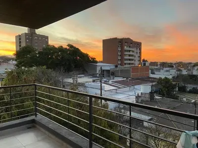 a view of a city at sunset from a balcony at LUMINOSO piso con jacuzzi in Alta Gracia