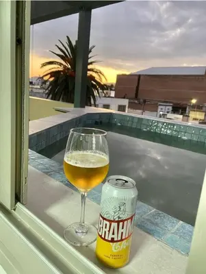 a glass of beer and a can on a balcony at LUMINOSO piso con jacuzzi in Alta Gracia