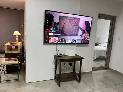 a living room with a television on a wall at LUMINOSO piso con jacuzzi in Alta Gracia