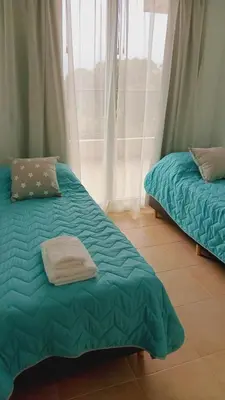 a bed with a green comforter in a room at Condominio Monte Molinos - dpto en Nautico, 2 dormitorios y vista al lago in Villa Ciudad de America