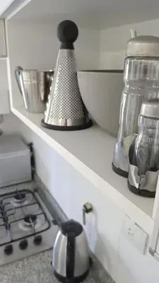 a kitchen counter with a tea kettle on top of a stove at Condominio Monte Molinos - dpto en Nautico, 2 dormitorios y vista al lago in Villa Ciudad de America