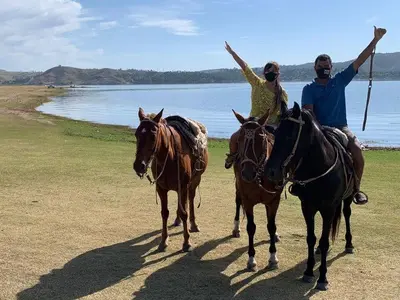 two people riding horses with their arms in the air at Condominio Monte Molinos - dpto en Nautico, 2 dormitorios y vista al lago in Villa Ciudad de America