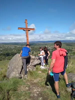 a group of people standing around a cross on a hill at Condominio Monte Molinos - dpto en Nautico, 2 dormitorios y vista al lago in Villa Ciudad de America