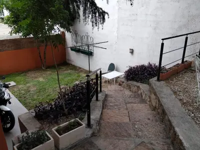 a garden with a bench next to a building at Los Zorzales in Villa Carlos Paz