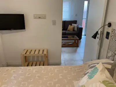 a bedroom with a bed and a living room with a couch at Los Zorzales in Villa Carlos Paz