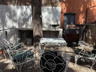 a group of chairs and a table and a tree at Los Zorzales in Villa Carlos Paz
