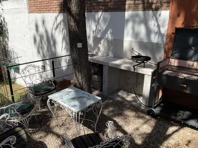 a patio with a grill and a table and chairs at Los Zorzales in Villa Carlos Paz