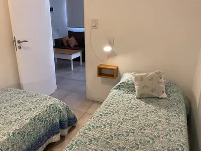 a small room with two beds and a table at Los Zorzales in Villa Carlos Paz