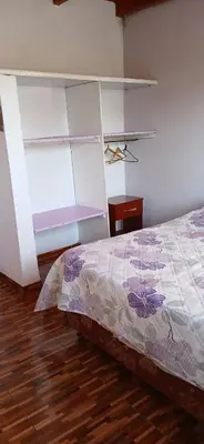 a bedroom with a bed and a wooden floor at El Molle in Estancia Vieja