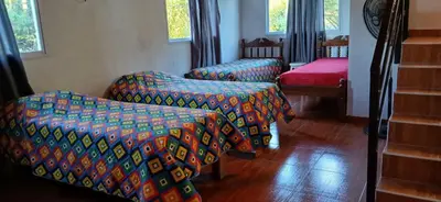 a room with two chairs and a bed and windows at El Molle in Estancia Vieja