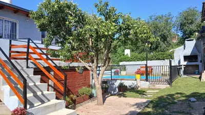 a tree in a yard next to a swimming pool at El Molle in Estancia Vieja