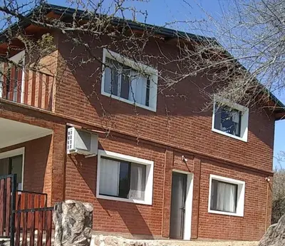 a red brick house with white windows on it at RESIDENCIA EL TALA in Cordoba