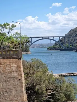 a bridge over a river with a bridge in the background at CABAÑA LA HERRADURA 14 in San Roque
