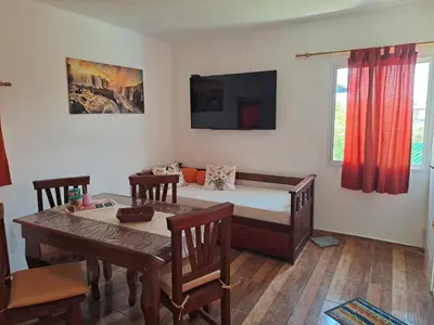 a bedroom with a bed and a table and chairs at CABAÑA LA HERRADURA 14 in San Roque
