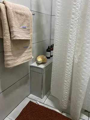 a bathroom with a shower with towels and a table at Apartamento Plaza Las Vertientes in Villa Carlos Paz