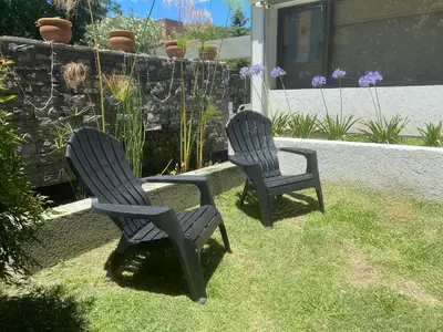 two chairs sitting in the grass in a yard at Apartamento Plaza Las Vertientes in Villa Carlos Paz