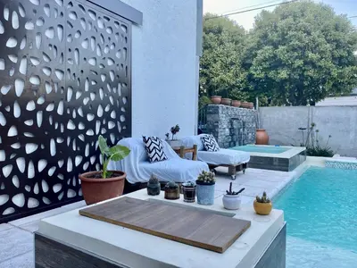 a patio with a table and chairs next to a pool at Apartamento Plaza Las Vertientes in Villa Carlos Paz