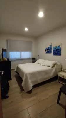 a bedroom with a large white bed and a window at Apartamento Plaza Las Vertientes in Villa Carlos Paz