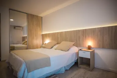a bedroom with a large bed and a mirror at Santa Cecilia Boutique in Villa Carlos Paz