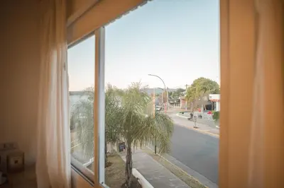 a window with a view of a palm tree at Santa Cecilia Boutique in Villa Carlos Paz