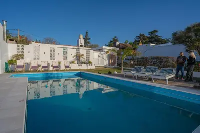 two people standing next to a swimming pool at Santa Cecilia Boutique in Villa Carlos Paz