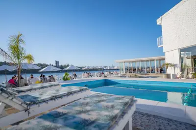 a swimming pool with people sitting around a building at Santa Cecilia Boutique in Villa Carlos Paz