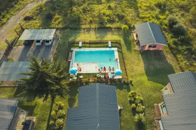 an overhead view of a pool with people standing around it at Pentagrama, casas de campo in Villa General Belgrano