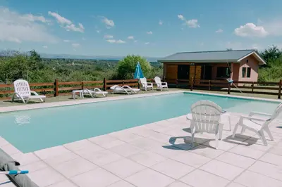 a swimming pool with chairs and a house at Pentagrama, casas de campo in Villa General Belgrano