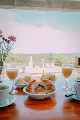 a table with plates of pastries and glasses of drinks at Pentagrama, casas de campo in Villa General Belgrano