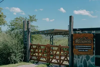 a sign in front of a gate with a fence at Pentagrama, casas de campo in Villa General Belgrano