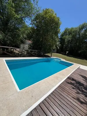 a large blue swimming pool on a wooden deck at Él Algarrobo in San Antonio de Arredondo