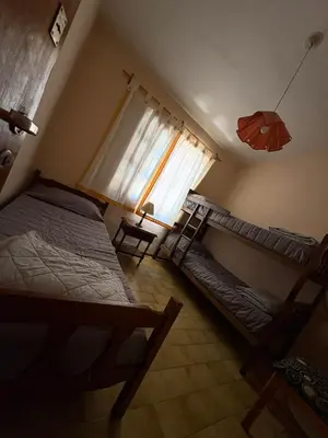 two beds in a room with a window and an umbrella at Él Algarrobo in San Antonio de Arredondo