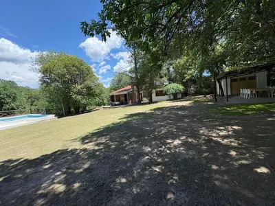 a large yard with a house and a tree at Él Algarrobo in San Antonio de Arredondo