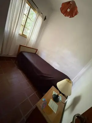 a bedroom with a bed and a table with a lamp at Él Algarrobo in San Antonio de Arredondo