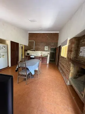 a kitchen and dining room with a table and a brick wall at Él Algarrobo in San Antonio de Arredondo