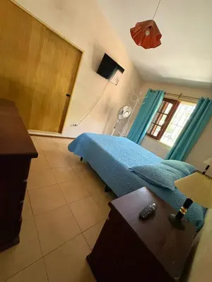 a bedroom with a bed with a blue blanket at Él Algarrobo in San Antonio de Arredondo