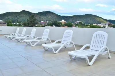 a row of white chairs sitting on a roof at Departamento centrico Villa Carlos Paz in Villa Carlos Paz