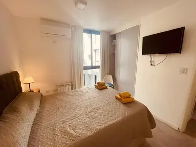 a bedroom with a bed with two yellow towels on it at Departamento centrico Villa Carlos Paz in Villa Carlos Paz