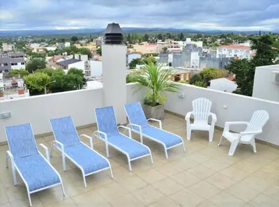 a balcony with blue and white chairs and a view at Departamento centrico Villa Carlos Paz in Villa Carlos Paz