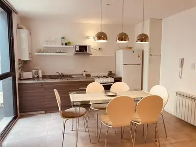 a kitchen with a table and chairs and a refrigerator at Departamento centrico Villa Carlos Paz in Villa Carlos Paz