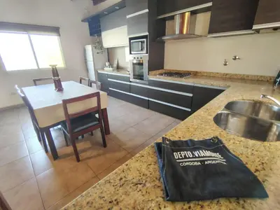 a kitchen with a sink and a table with a counter at Depto Viamonte PlantaAlta, 2Dorm, Terraza, Cochera in Cordoba