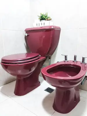 a red toilet and a bidet in a bathroom at Depto Viamonte PlantaAlta, 2Dorm, Terraza, Cochera in Cordoba