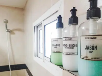 a group of bottles sitting on a shelf in a bathroom at Depto Viamonte PlantaAlta, 2Dorm, Terraza, Cochera in Cordoba