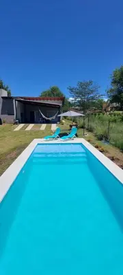 a large swimming pool in a yard with a house at Casa en Potrero de Garay con pileta in Potrero de Garay