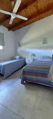 a bedroom with two beds and a ceiling fan at Casa en Potrero de Garay con pileta in Potrero de Garay