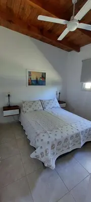 a white bed in a bedroom with a ceiling at Casa en Potrero de Garay con pileta in Potrero de Garay